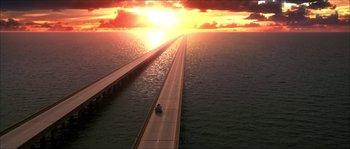 Movie still from “The Haunted Mansion” (2003), directed by Rob Minkoff – An aerial view of an ocean with a car driving on it; Extreme Wide shot, High angle