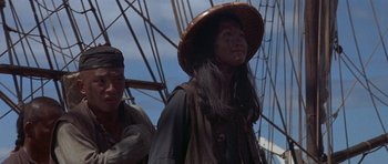 Movie still from “The Hawaiians” (1970), directed by Tom Gries – A woman in a hat and a man in a hat; Medium shot, Low angle