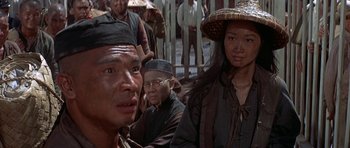 Movie still from “The Hawaiians” (1970), directed by Tom Gries – A man and a woman wearing hats in front of a group of people; Close Up shot, Over the shoulder angle