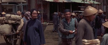 Movie still from “The Hawaiians” (1970), directed by Tom Gries – A group of people standing on top of a dirt field; Medium shot, Over the shoulder angle