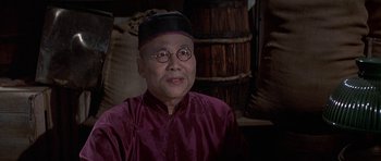 Movie still from “The Hawaiians” (1970), directed by Tom Gries – An older man wearing a purple shirt and a black hat; Close Up shot, Over the shoulder angle