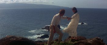 Movie still from “The Hawaiians” (1970), directed by Tom Gries – A man and a woman walking on a cliff near the ocean; Wide shot, Low angle
