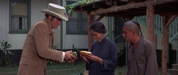 Movie still from “The Hawaiians” (1970), directed by Tom Gries – A man and a woman are holding a sandwich; Medium shot, Over the shoulder angle