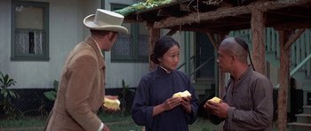 Movie still from “The Hawaiians” (1970), directed by Tom Gries – A woman in a cowboy hat holding a piece of food; Medium shot, Over the shoulder angle