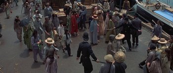 Movie still from “The Hawaiians” (1970), directed by Tom Gries – A group of people are gathered around a man in a uniform; Extreme Wide shot, High angle