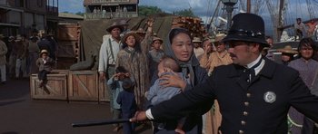 Movie still from “The Hawaiians” (1970), directed by Tom Gries – A group of people standing next to each other on a bridge; Medium shot, Over the shoulder angle