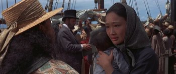 Movie still from “The Hawaiians” (1970), directed by Tom Gries – A woman holding a baby on a boat in the ocean; Close Up shot, Over the shoulder angle