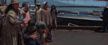 Movie still from “The Hawaiians” (1970), directed by Tom Gries – A group of people standing next to each other on a dock; Wide shot, High angle