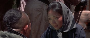 Movie still from “The Hawaiians” (1970), directed by Tom Gries – A woman wearing a headscarf is looking into the camera; Close Up shot, Over the shoulder angle
