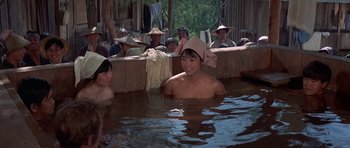 Movie still from “The Hawaiians” (1970), directed by Tom Gries – A group of people sitting in a pool of water; Medium shot, High angle