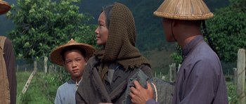 Movie still from “The Hawaiians” (1970), directed by Tom Gries – An asian woman wearing a head scarf and a hat; Medium shot, Over the shoulder angle