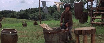 Movie still from “The Hawaiians” (1970), directed by Tom Gries – A young boy washing clothes in an old wash tub; Wide shot, Low angle