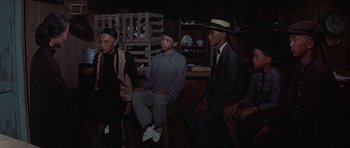Movie still from “The Hawaiians” (1970), directed by Tom Gries – A group of young men sitting in a room; Medium shot, High angle
