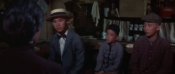 Movie still from “The Hawaiians” (1970), directed by Tom Gries – Two young men sitting next to each other in a room; Medium shot, Over the shoulder angle