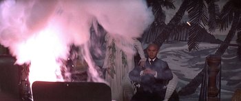 Movie still from “The Hawaiians” (1970), directed by Tom Gries – A man sitting in a chair in front of a cloud of smoke; Medium shot, Low angle