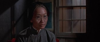 Movie still from “The Hawaiians” (1970), directed by Tom Gries – An asian woman wearing glasses and a head scarf; Close Up shot, Over the shoulder angle