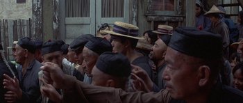 Movie still from “The Hawaiians” (1970), directed by Tom Gries – A group of people wearing hats in front of a building; Medium shot, High angle