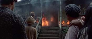 Movie still from “The Hawaiians” (1970), directed by Tom Gries – A group of people standing outside of a house on fire; Wide shot, Over the shoulder angle