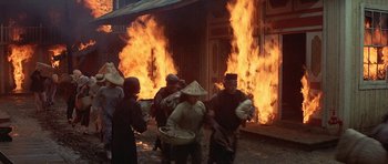 Movie still from “The Hawaiians” (1970), directed by Tom Gries – A group of people walking in front of a burning building; Wide shot, High angle