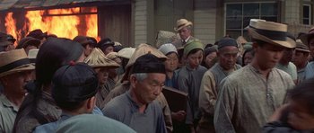 Movie still from “The Hawaiians” (1970), directed by Tom Gries – A group of people standing in front of a building; Medium shot, High angle
