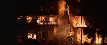 Movie still from “The Hawaiians” (1970), directed by Tom Gries – A building on fire at night with people sitting on it; Extreme Wide shot, Low angle