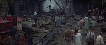 Movie still from “The Hawaiians” (1970), directed by Tom Gries – A group of men standing around a pile of debris; Wide shot, High angle