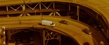 Movie still from “The Heat” (2013), directed by Paul Feig – A white van driving down a curvy road; Extreme Wide shot, Overhead angle