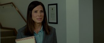 Movie still from “The Heat” (2013), directed by Paul Feig – A woman in a gray jacket and a blue shirt; Close Up shot, Over the shoulder angle