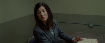 Movie still from “The Heat” (2013), directed by Paul Feig – A woman sitting at a table in front of a window; Close Up shot, Over the shoulder angle