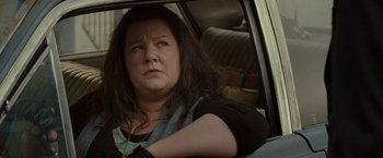 Movie still from “The Heat” (2013), directed by Paul Feig – A woman sitting in the back seat of a car; Close Up shot, High angle