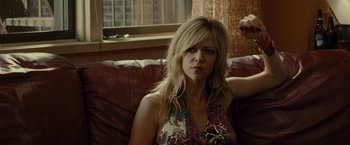 Movie still from “The Heat” (2013), directed by Paul Feig – A woman sitting on top of a couch in a living room; Close Up shot, Over the shoulder angle