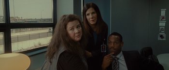 Movie still from “The Heat” (2013), directed by Paul Feig – A group of people standing next to each other in a room; Close Up shot, Over the shoulder angle