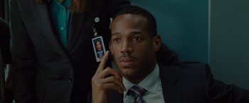 Movie still from “The Heat” (2013), directed by Paul Feig – A man in a suit and tie holding a cell phone to his ear; Close Up shot, Over the shoulder angle