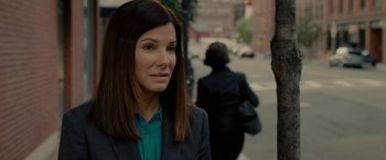 Movie still from “The Heat” (2013), directed by Paul Feig – A woman in a green shirt and a black suit; Close Up shot, Over the shoulder angle