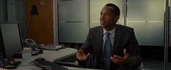 Movie still from “The Heat” (2013), directed by Paul Feig – A man sitting at a desk in front of a computer; Medium shot, Over the shoulder angle