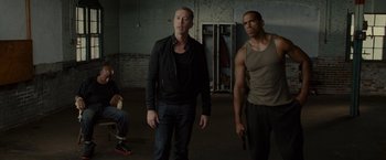 Movie still from “The Heat” (2013), directed by Paul Feig – A group of men standing next to each other in a room; Medium shot, Over the shoulder angle