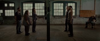 Movie still from “The Heat” (2013), directed by Paul Feig – A group of people standing in a room with windows; Wide shot, High angle