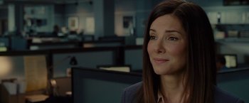 Movie still from “The Heat” (2013), directed by Paul Feig – A person wearing a suit and smiling; Close Up shot, Over the shoulder angle