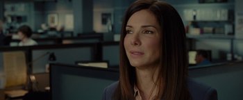 Movie still from “The Heat” (2013), directed by Paul Feig – A woman in a suit looking to her left; Close Up shot, Over the shoulder angle