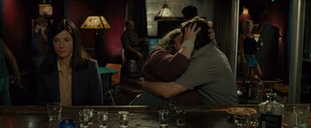 Movie still from “The Heat” (2013), directed by Paul Feig – A man and a woman hugging in a room; Wide shot, Over the shoulder angle