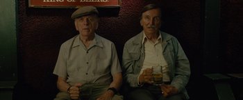 Movie still from “The Heat” (2013), directed by Paul Feig – Two men sitting next to each other holding drinks; Close Up shot, High angle