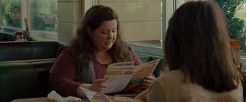 Movie still from “The Heat” (2013), directed by Paul Feig – A woman sitting at a table looking at a menu; Close Up shot, Over the shoulder angle