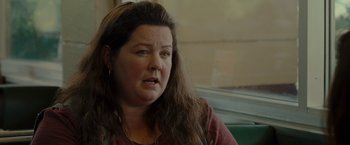 Movie still from “The Heat” (2013), directed by Paul Feig – A person sitting on a chair; Close Up shot, Over the shoulder angle