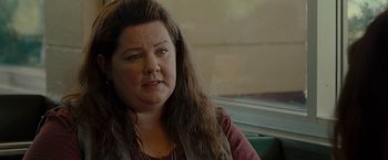 Movie still from “The Heat” (2013), directed by Paul Feig – A person sitting on a train; Close Up shot, Over the shoulder angle