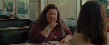 Movie still from “The Heat” (2013), directed by Paul Feig – A woman sitting in front of a window at a table; Close Up shot, Over the shoulder angle