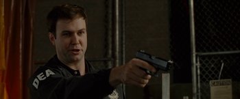 Movie still from “The Heat” (2013), directed by Paul Feig – A man holding a gun in his hand; Close Up shot, Over the shoulder angle