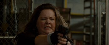Movie still from “The Heat” (2013), directed by Paul Feig – A woman holding a gun in her right hand; Close Up shot, Low angle