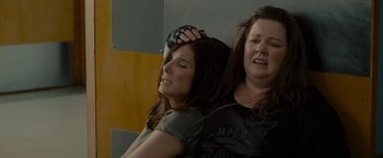 Movie still from “The Heat” (2013), directed by Paul Feig – Two women sitting next to each other on a wall; Close Up shot, Overhead angle