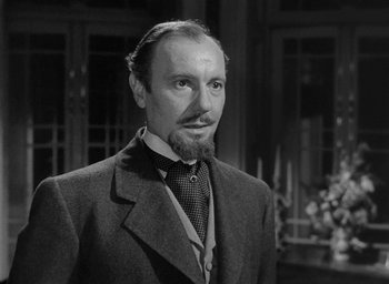 Movie still from “The Heiress” (1949), directed by William Wyler – A man in a suit and tie standing in front of a building; Close Up shot, Low angle