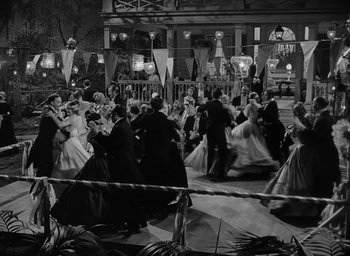 Movie still from “The Heiress” (1949), directed by William Wyler – A black and white photo of people dancing in formal wear; Wide shot, High angle